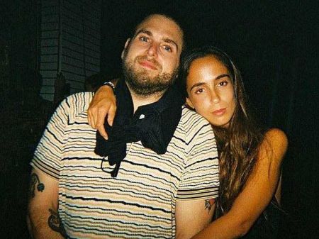 gianna with her hands around jonah's neck 